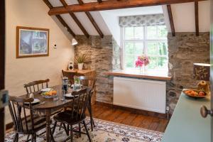 jadalnia ze stołem i krzesłami oraz oknem w obiekcie Brynarth Country Cottages w Aberystwyth
