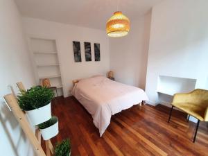 a bedroom with a bed and a potted plant at Home Sweet Home Ordener Marcadet in Paris
