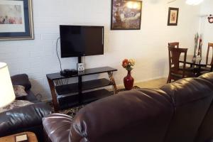 sala de estar con sofá de cuero y TV de pantalla plana en Tempe ASU Hot location 2 Bed Cozy Convenient en Tempe