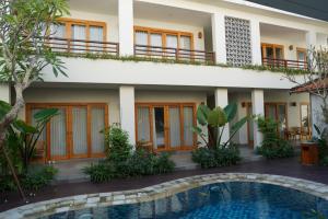 a hotel with a swimming pool in front of a building at Umah Anyar in Canggu