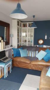 高威的住宿－Galway City Lovely 2 Bed Apartment，客厅设有棕色沙发和蓝色的墙壁。