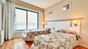 een hotelkamer met 2 bedden en een raam bij Amplio, moderno e impecable departamento en la mejor ubicacion de Mendoza in Mendoza