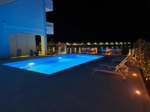 a swimming pool on the side of a building at night at Apartmani Barka in Neum
