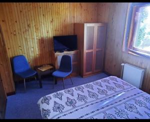 a bedroom with a bed and two chairs and a desk at Vila Kamila in Tatranska Strba