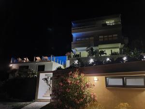 a building with lights on the side of it at night at Apartmani Barka in Neum