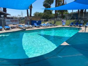 a swimming pool with a pool table and chairs at CCBC Resort Hotel - A Gay Men's Resort in Cathedral City