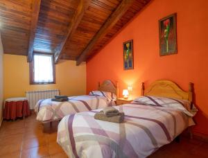 3 camas en una habitación con paredes de color naranja en Turismo Rural Castell, en Neril