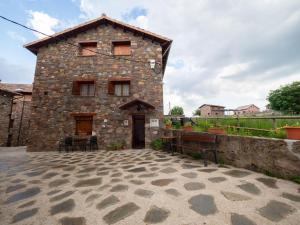 un edificio de piedra con una mesa y sillas delante de él en Turismo Rural Castell, en Neril