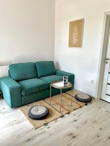 un soggiorno con divano verde e tavolo di P&P APARTMÁNY Bojnice a Bojnice