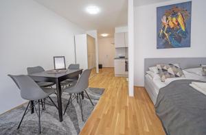 - un salon avec une table, des chaises et un lit dans l'établissement Meraki Apartment, à Vienne