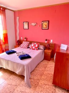 1 dormitorio con cama y pared roja en APARTBEACH MAR INTERNUM III VISTAS PLAYA y PARKING en La Pineda