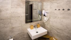 ein Badezimmer mit einem weißen Waschbecken und einem Spiegel in der Unterkunft Flying Bed Apartment close to Prague Castle and Airport in Prag