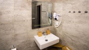 a bathroom with a white sink and a mirror at Flying Bed Apartment close to Prague Castle and Airport in Prague