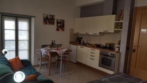 a kitchen with a table and a kitchen with white cabinets at APPARTAMENTS SUPERIOR ,o SUITE GARDARCO in Arco