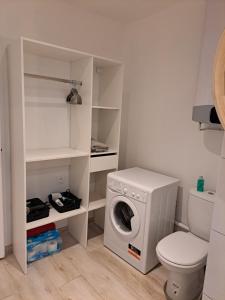 a bathroom with a washing machine and a toilet at échappée belle en plein cœur d auxerre in Auxerre