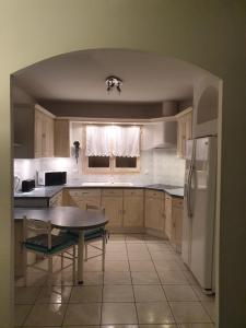 a kitchen with white cabinets and a table in it at La villa d elisa in Leucate
