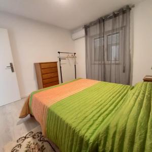 a bedroom with a bed with a green blanket at Casa Rural "Casa da Professora" - Meãs, Pampilhosa da Serra in Pampilhosa da Serra