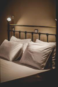 a bed with white pillows on top of it at Hotel EPIDAVROS in Nafplio