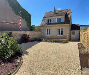 a house with a gravel driveway in front of it at Maison cosy en plein coeur de Ouistreham in Ouistreham