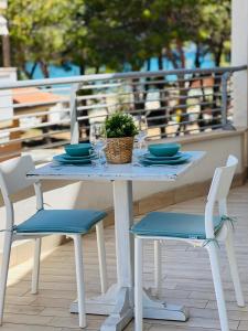 シルヴィ・マリーナにあるBeach apartments Spiaggia Nascostaの白いテーブル(椅子2脚付)と鉢植え