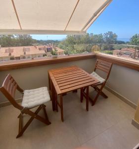 a wooden table and two chairs on a balcony at Duplex de lujo Marbella- Dunas de Artola in Marbella