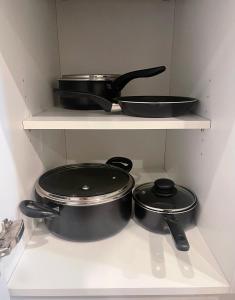 two pots and pans sitting on shelves in a kitchen at Modern Downtown Houston Condo Nightlife & Food Scene in Houston