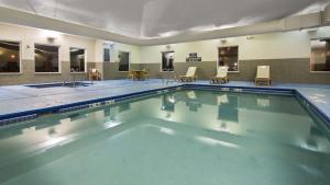 una gran piscina en una habitación con mesas y sillas en Best Western Legacy Inn & Suites Beloit/South Beloit, en South Beloit