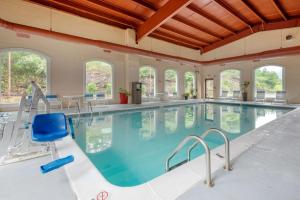una gran piscina con una silla azul en un edificio en BEST WESTERN PLUS Poconos, en Tannersville