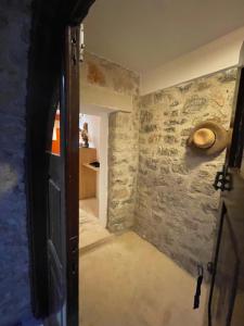 uma porta aberta para um quarto com uma parede de pedra em villa Elpiniki Tilos em Megálon Choríon