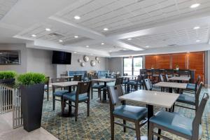 Best Western Plus McAllen Airport Hotel في ماكالين: غرفة طعام مع طاولات وكراسي في مطعم