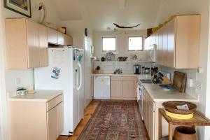 a kitchen with white cabinets and a refrigerator at Valleys & Views in Nantucket