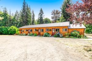 a large wooden cabin with a driveway at Mount Ellinor, Room 11 at Mount Walker Inn in Quilcene
