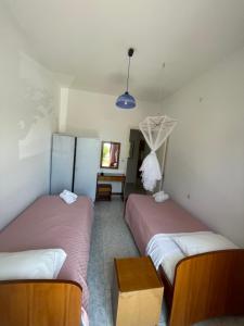 una camera con due letti e un tavolo di NAFSIKA Apartments ad Agios Georgios Pagon