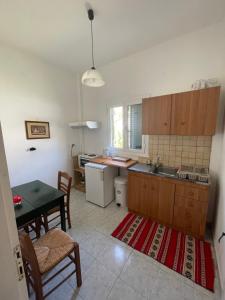 una cucina con tavolo e una sala da pranzo di NAFSIKA Apartments ad Agios Georgios Pagon