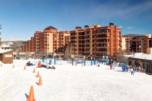 una playa con conos naranjas en la nieve frente a los edificios en Peak 9 Studio of Dreams, en Breckenridge