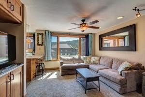 Una sala de estar con un sofá y un ventilador de techo. en Peak 9 Studio of Dreams, en Breckenridge