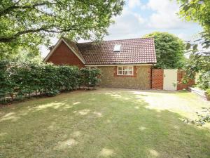 a red brick house with a large yard at Oak Tree Lodge in Rackheath