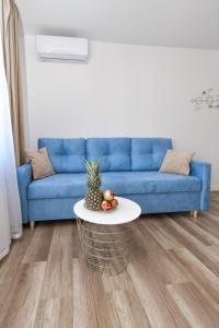 een woonkamer met een blauwe bank en een tafel bij Apartamenty Majka in Zator
