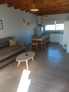 een woonkamer met een bank en een tafel bij Duplex familiar con pileta en zona parque in Necochea