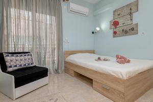 Melody Apartment في Néa Khilí: غرفة نوم بسرير وكرسي