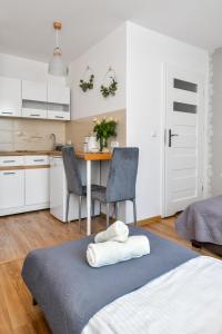 a bedroom with a bed and a table with chairs at Apartamenty Majka in Zator
