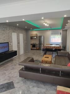 a large living room with a couch and a tv at Nurmi House in Hajdúszoboszló