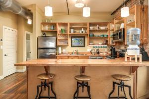 a kitchen with a large wooden counter and stools at Nooga Loft in Chattanooga