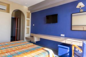 a bedroom with a blue bed and blue walls at Mariandy Hotel in Larnaca