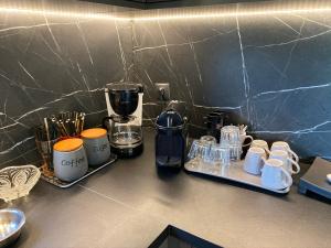 a counter top with a coffee maker and cups on it at Villa Gloria Plataria in Igoumenitsa