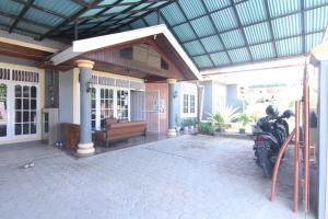 a house with a motorcycle parked on a patio at New Bunga Sonsang Homestay Syariah in Tabing