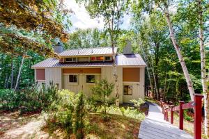 una pequeña casa en el bosque con una valla roja en The Mountain Escape, en Lincoln