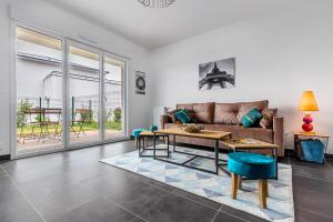 a living room with a couch and a table at King Size Bed - Free Private Parking - Garden & Terrace - 14min from DisneyLand in Ferrières-en-Brie