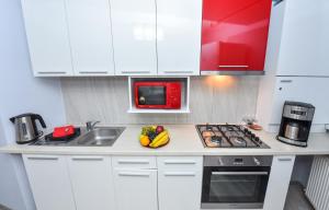 a kitchen with white cabinets and a sink with fruit on the counter at Residenza di Carbasinni in Bucharest