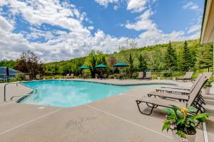 una piscina con dos sillas y una mesa en White Mountain Retreat, en Lincoln